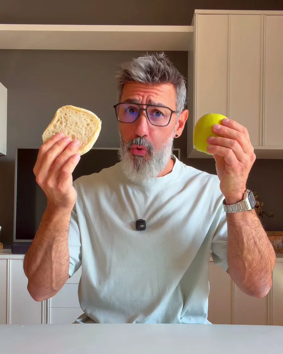 Jonathan con una rebanada de pan en una mano y una manzana en la otra